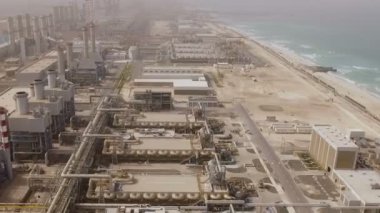 Borular, hangarlar ve yollar ile büyük bir santral hava görünümünü deniz kıyısında. Dubai, Birleşik Arap Emirlikleri