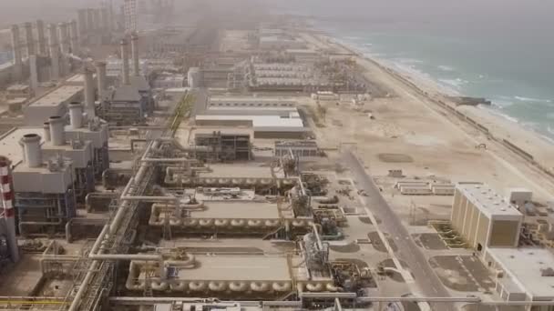 Borular, hangarlar ve yollar ile büyük bir santral hava görünümünü deniz kıyısında. Dubai, Birleşik Arap Emirlikleri — Stok video