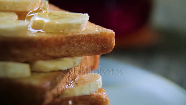 Toast fresco fatto in casa croccante con miele e banane sul piatto blu. Deliziosa colazione . — Video Stock