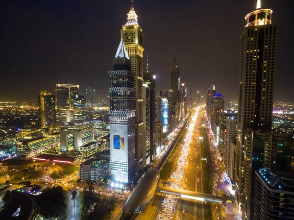 Yollar, gökdelenler ve parlak ışıklar ile Dubai şehrinin gece görünümü — Stok fotoğraf
