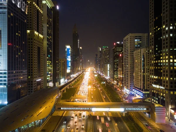 Yollar, gökdelenler ve parlak ışıklar ile Dubai şehrinin gece görünümü — Stok fotoğraf