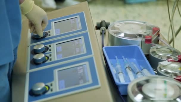 Перфузионист управляет аппаратом искусственного кровообращения в операционной. Крупный план — стоковое видео