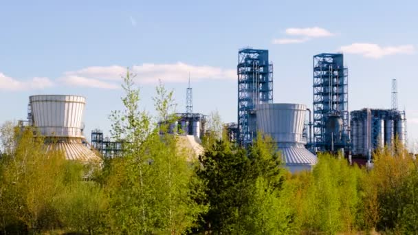 Нафтопереробний завод з зеленим листям на передньому плані. Промисловість та довкілля разом — стокове відео