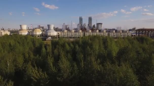 Величезний нафтопереробний завод з трубами і дистиляцією комплексу поруч з лісом. Вид з повітря — стокове відео