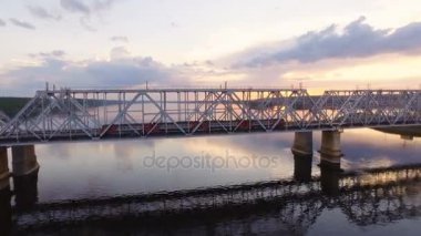 Demiryolu köprüsü üzerinde yolcu treni gider Volga Nehri. Havadan görünümü