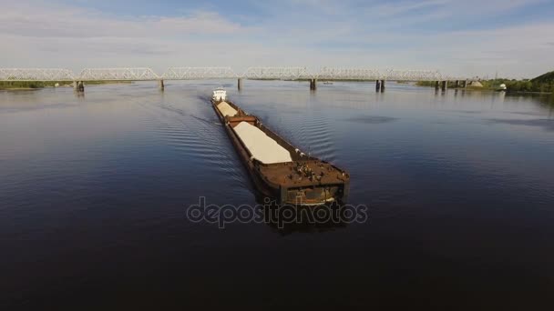 Barka ładowane z piasku i żwiru unosi się na szerokiej rzeki, na tle mostu. Widok z lotu ptaka — Wideo stockowe