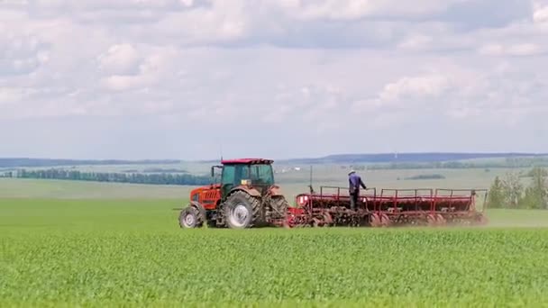 Весной трактор вспахивает поля — стоковое видео