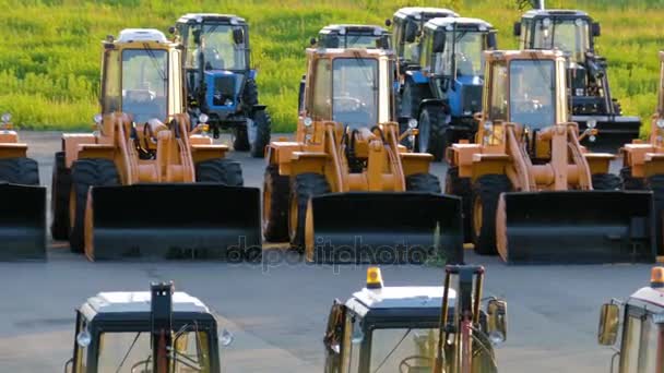 Equipos de construcción nuevos, excavadoras y tractores en el estacionamiento — Vídeos de Stock