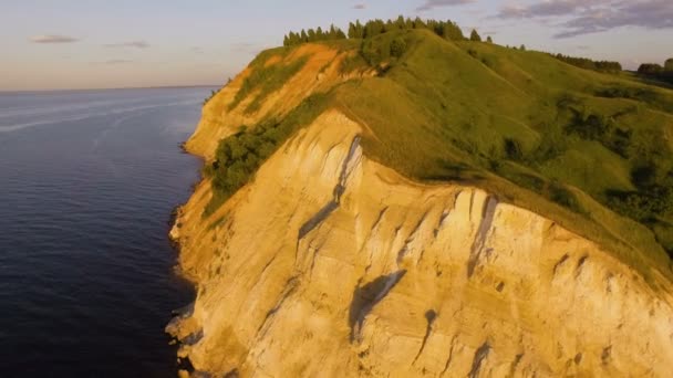 Beautiful aerial view of cliff with trees and grass on the rivers edge — Stock Video