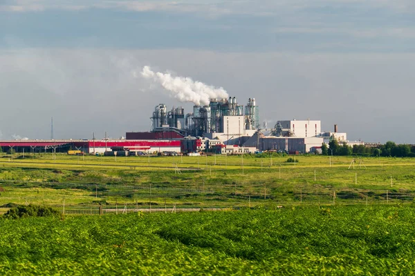 Una enorme planta de hormigón con tuberías entre los campos —  Fotos de Stock