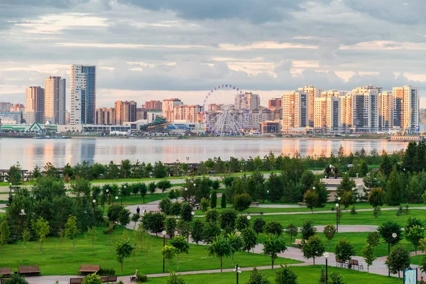 Beautiful urban landscape with a road, a Park and a lake at sunset — Stock Photo, Image