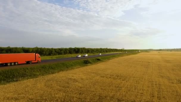 Hermosa vista aérea de la carretera con montando camión rojo y coches en el campo — Vídeos de Stock