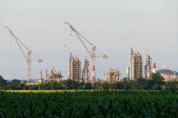 Una enorme refinería de petróleo con grúas en construcción — Foto de Stock