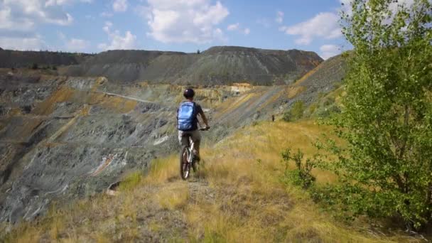 En ung man på en cykel Rider längs klippan i kanjonen — Stockvideo