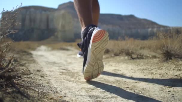 Läuferfüße laufen in Nahaufnahme auf Schuhen über die Straße. Zeitlupe — Stockvideo