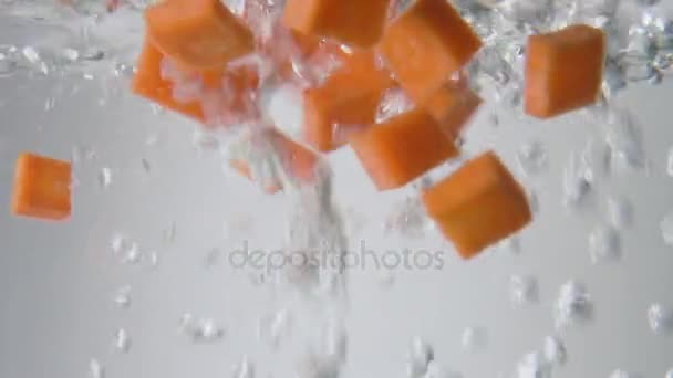 Морковные ломтики падают в кипящую воду. Макровзгляд — стоковое видео