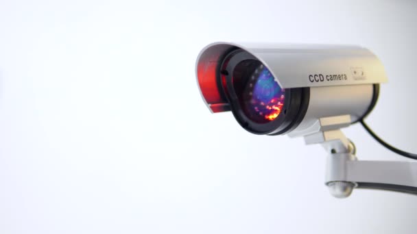 The surveillance camera with flashing red light on white background. Close up — Stock Video