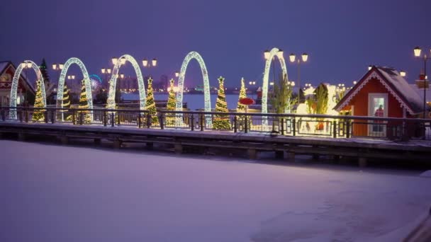 Donmuş bir gölün iskelede kazan şehir yeni yıl süslemeleri ile dekore edilmiş — Stok video