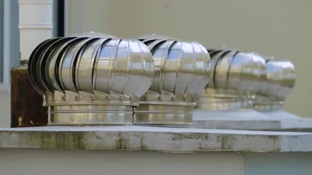 I ventilatori a turbina girevole in metallo argento comunemente noti come sfiati del tetto "vortici" installati sul tetto sono il modo più efficace e conveniente di raffreddamento all'interno di una casa — Video Stock