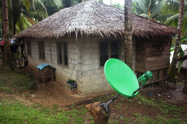 Moderní satelitní anténa vedle boudy mezi palmami. Filipíny — Stock fotografie