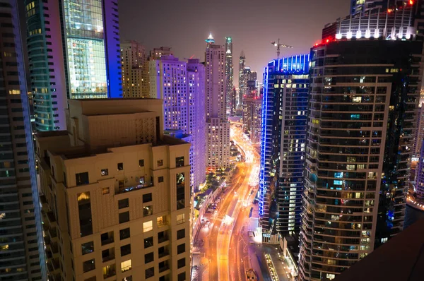 Yollar, gökdelenler ve parlak ışıklar ile Dubai şehrinin gece görünümü — Stok fotoğraf