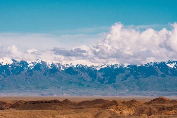 Панорама гарний краєвид з деревами і полів на передньому плані і гірські хребти з засніжені у фоновому режимі. Казахстан — стокове фото