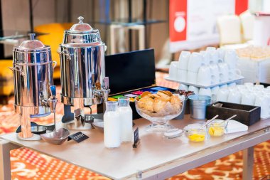 Kahve, süt şişeleri, konferansta yemek masasında fincanlar. Açık büfede kahve ya da çay içmek için boş beyaz seramik bardaklar grubu iş toplantısı ya da otel etkinliği.