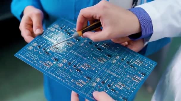 Mani maschili e femminili tengono la scheda elettronica del computer e mostrano i suoi dettagli. Chiudete. Hardware del computer. Saldatore. Dispositivo digitale. Scheda madre in Mani. Concetto di dispositivi elettronici — Video Stock