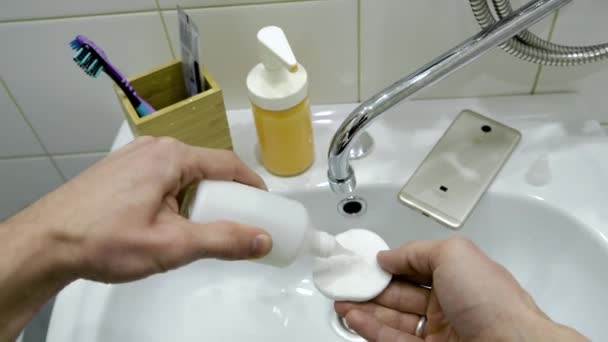 Férfi kéz használ egy speciális folyadék fertőtleníteni a kezét, és a telefon a fürdőszobában. Első személyű nézet — Stock videók