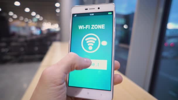 Mano tenendo smart phone con segno wifi gratuito sullo schermo su sfondo sfocato, business e concetto di tecnologia — Video Stock