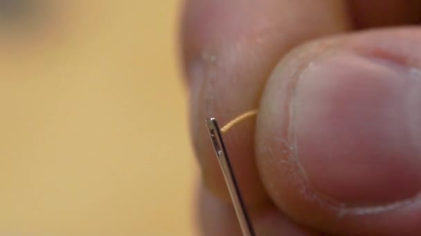 Enfiar na agulha. Close-up de homem puxando fio na agulha — Vídeo de Stock