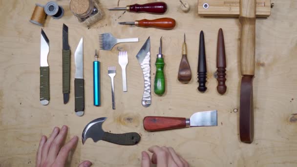Närbild av manliga master skärande bit läder med hantverk verktyg för framtida plånbok på verkstad. Hög vinkel syn på skomakare arbetsplats — Stockvideo