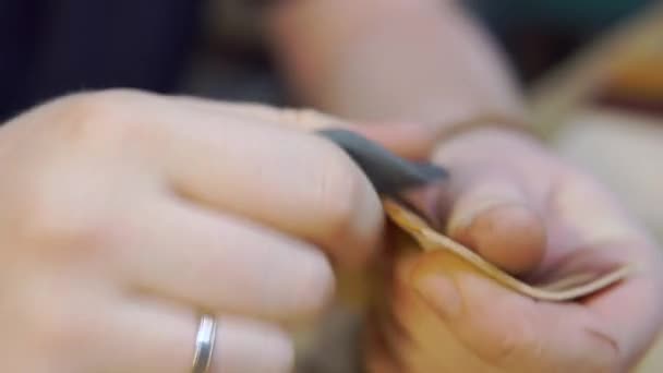 Processo di lavorazione della cintura in pelle marrone nel laboratorio di pelletteria. Mans mani creando nuova cintura alla moda. Lucidatura dei bordi — Video Stock