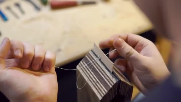 ワークショップで針縫いの革を持つ男 — ストック動画