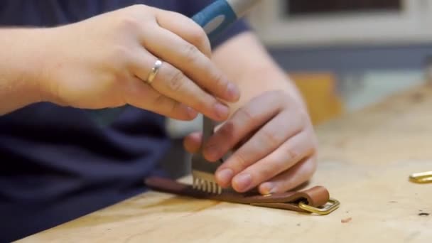 남성 마스터 컷의 가죽 조각을 클로즈업 한 후 워크 샵에서 미래의 지갑을 위한 도구를 만들었습니다. 코블러가 일하는 곳을 확대 한 모습 — 비디오