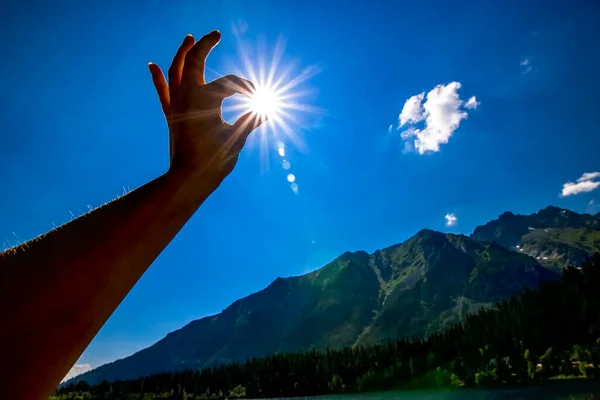 sun in hand with blue sky in background