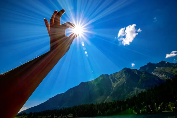 sun in hand with blue sky in background