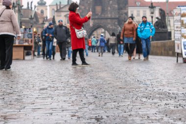 Arka planda Gotik mimarisi olan Charles Köprüsü. Çin 'den bir grup turist