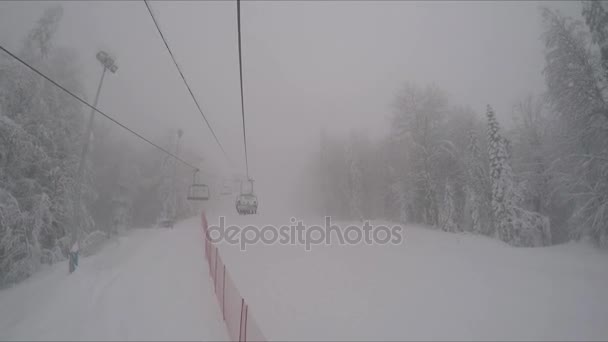Chairs of a ski lift into the fog — Stock Video