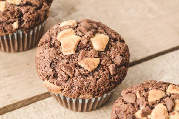 Three chocolate muffins lined up diagonally.