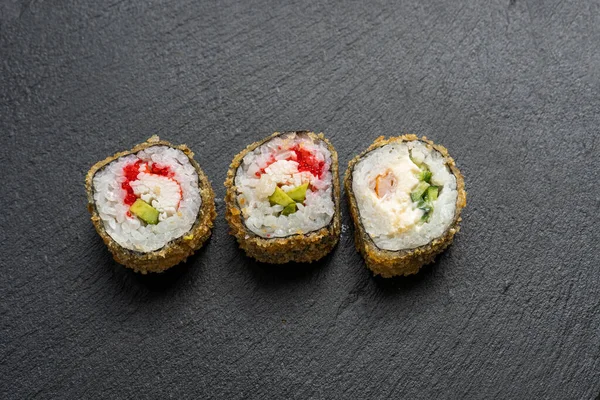 Somon, yılan balığı, ton balığı, avokado, kraliyet karidesi, Philadelphia krem peyniri, havyar tobika, chuka. Siyah arkaplan.