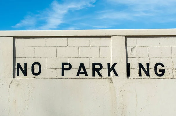 No hay letrero de estacionamiento pintado en una vieja pared de hormigón . — Foto de Stock