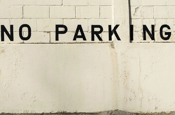 No hay letrero de estacionamiento pintado en una vieja pared de hormigón . — Foto de Stock