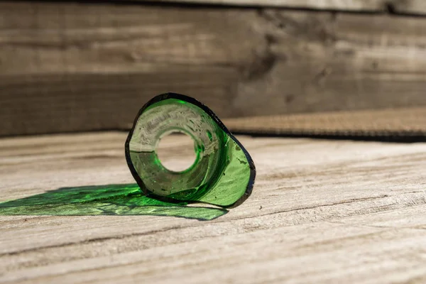 Frasco de vidrio verde roto con fondo de madera . —  Fotos de Stock