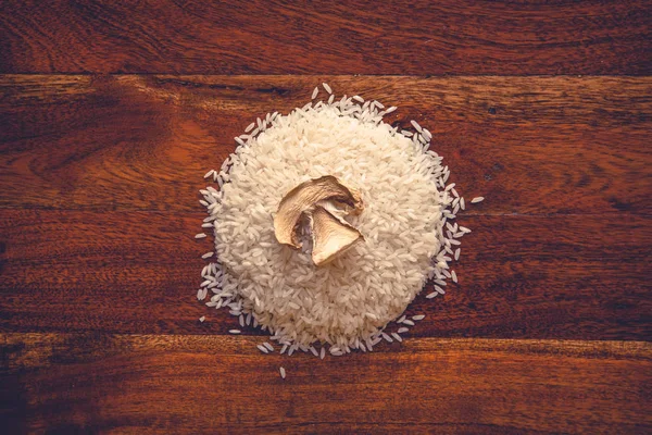 Organic dried portobello mushroom on pile of rice on rustic background