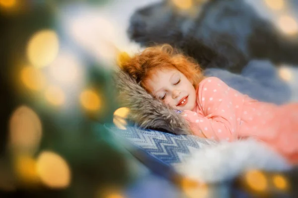 Petite fille qui dort en pyjama rose qui attend le Père Noël à Noël — Photo