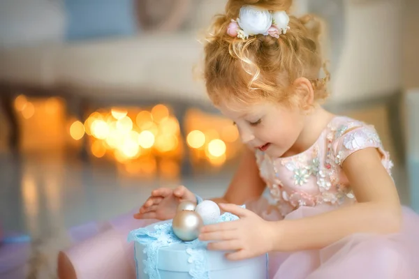 Niña de 5 años en hermoso vestido rosa claro con una caja de regalo azul — Foto de Stock