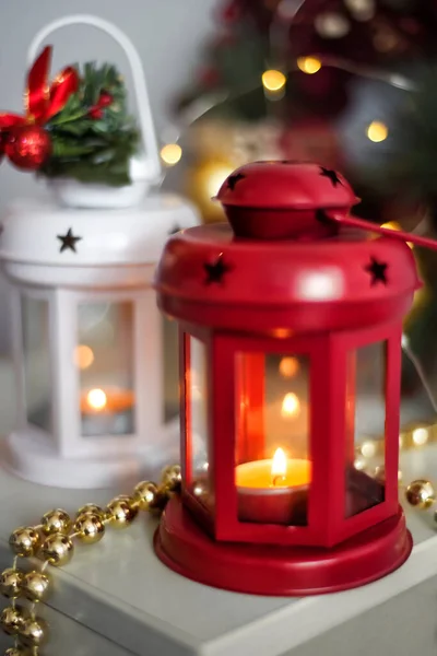 Vintage Christmas Lanterns Red and White with burning Candles. Cozy christmas decorations with golden beads, balls. Christmas tree on background — Stock Photo, Image
