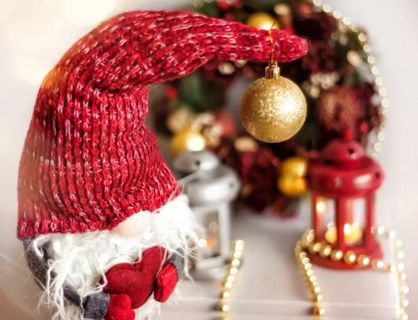 Lanternas de Natal vintage Vermelho e cinza com velas em chamas e anão cinza em chapéu vermelho com coração vermelho nas mãos. Decorações de Natal acolhedoras com contas douradas e bolas. Árvore de Natal no fundo — Fotografia de Stock