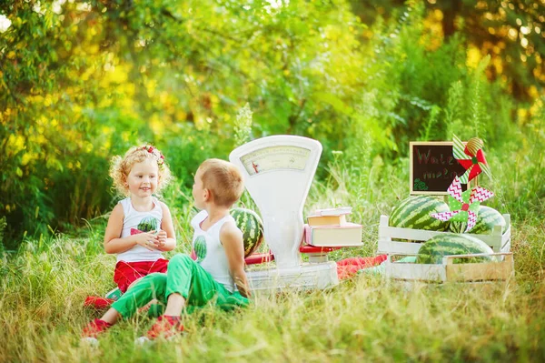 Geschwister spielen in Wassermelonenverkäufern mit altmodischen weißen Waagen. Emotionale Kinder schauen Mädchen mit großen Wassermelonen im Park an. gesunde Biolebensmittel für Kinder — Stockfoto